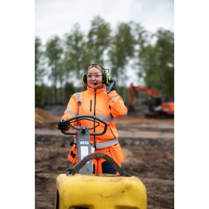 MRX21A4WS6, PELTOR, colore giallo fluo, cuffie attive da bardatura temporale, con operatrice che le utilizza in un cantiere