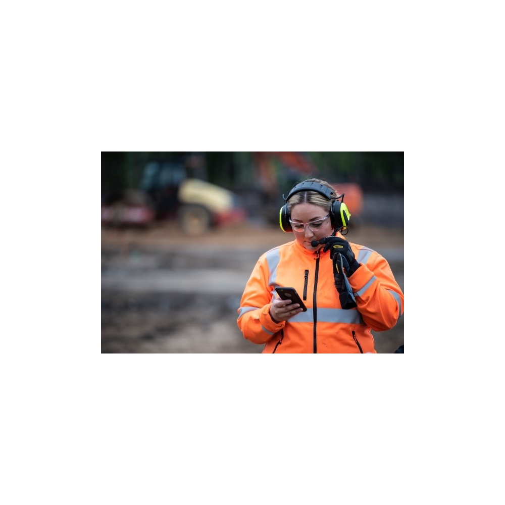 MRX21A4WS6, PELTOR, colore giallo fluo, cuffie attive da bardatura temporale, con operatrice che le utilizza in un cantiere